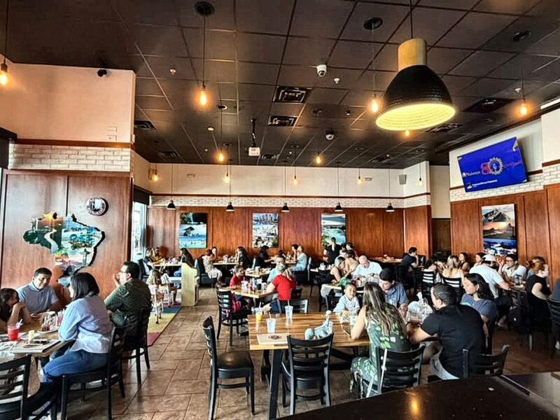 Families and groups sharing tables in the dining room at Boteco Restaurant on International Drive, Orlando