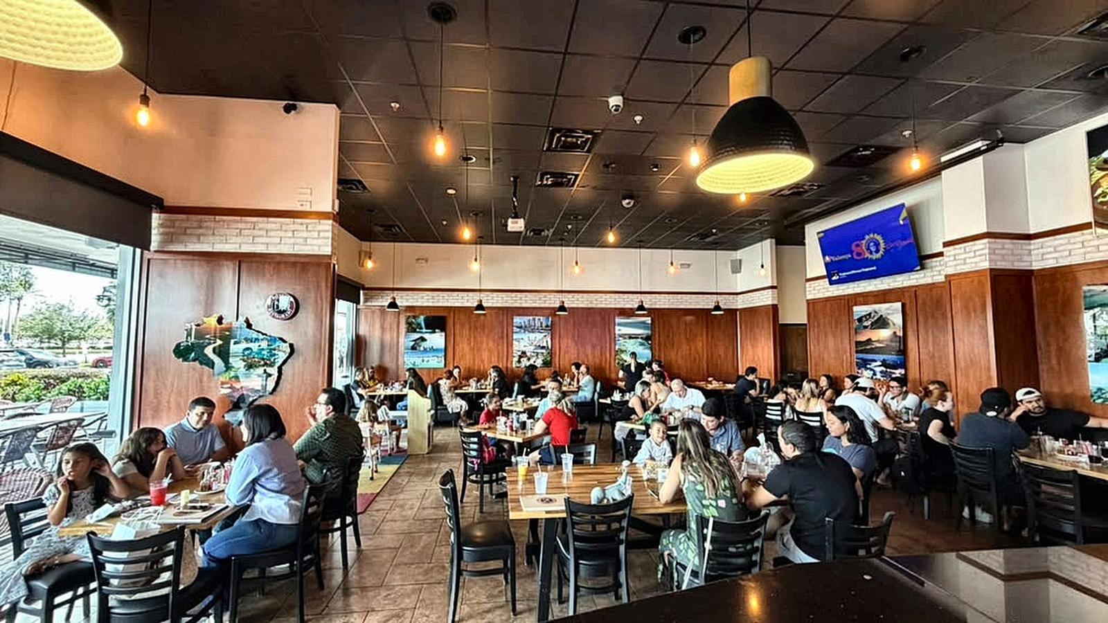 Families and groups sharing tables in the dining room at Boteco Restaurant on International Drive, Orlando